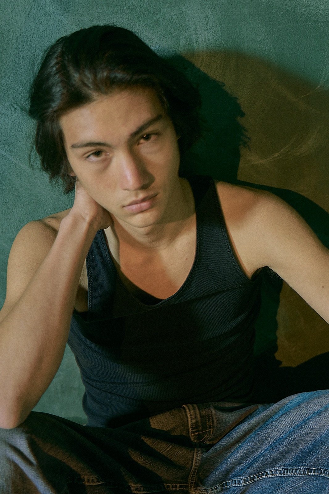 Black tank against a teal wall