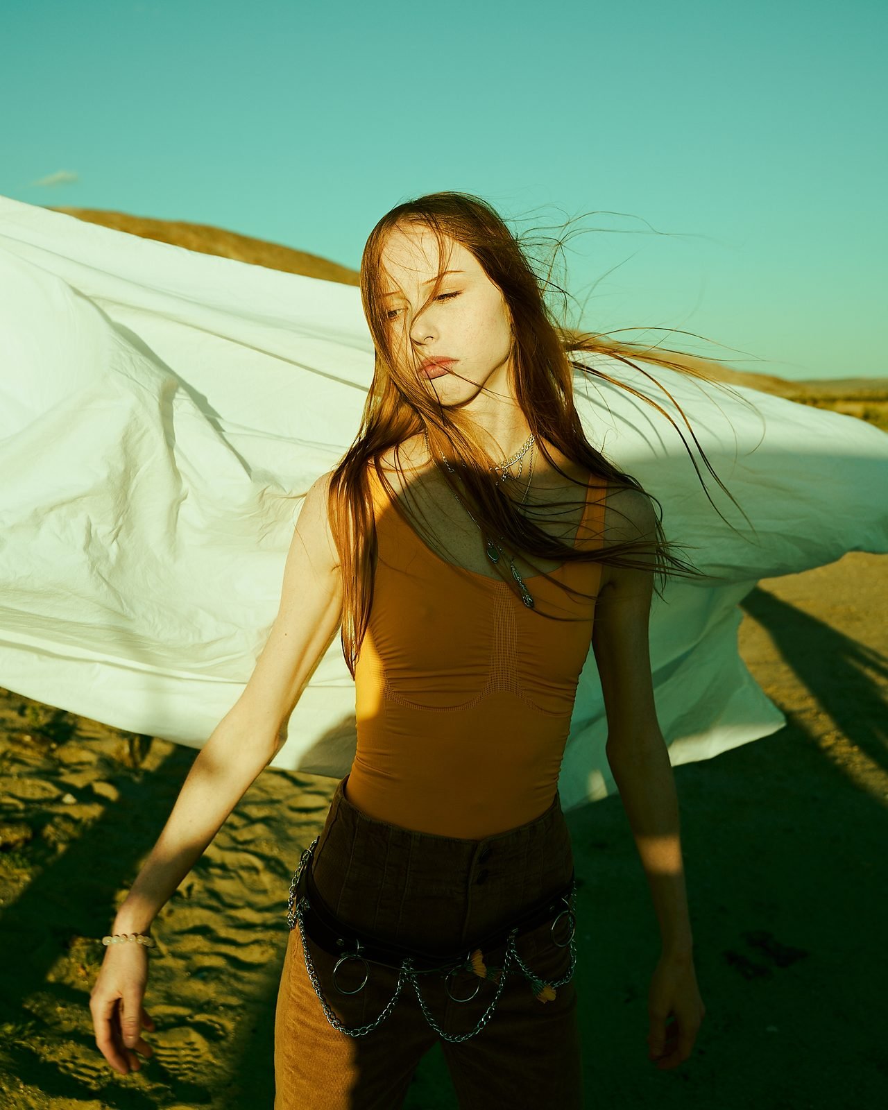Orange bodysuit, white sheet
