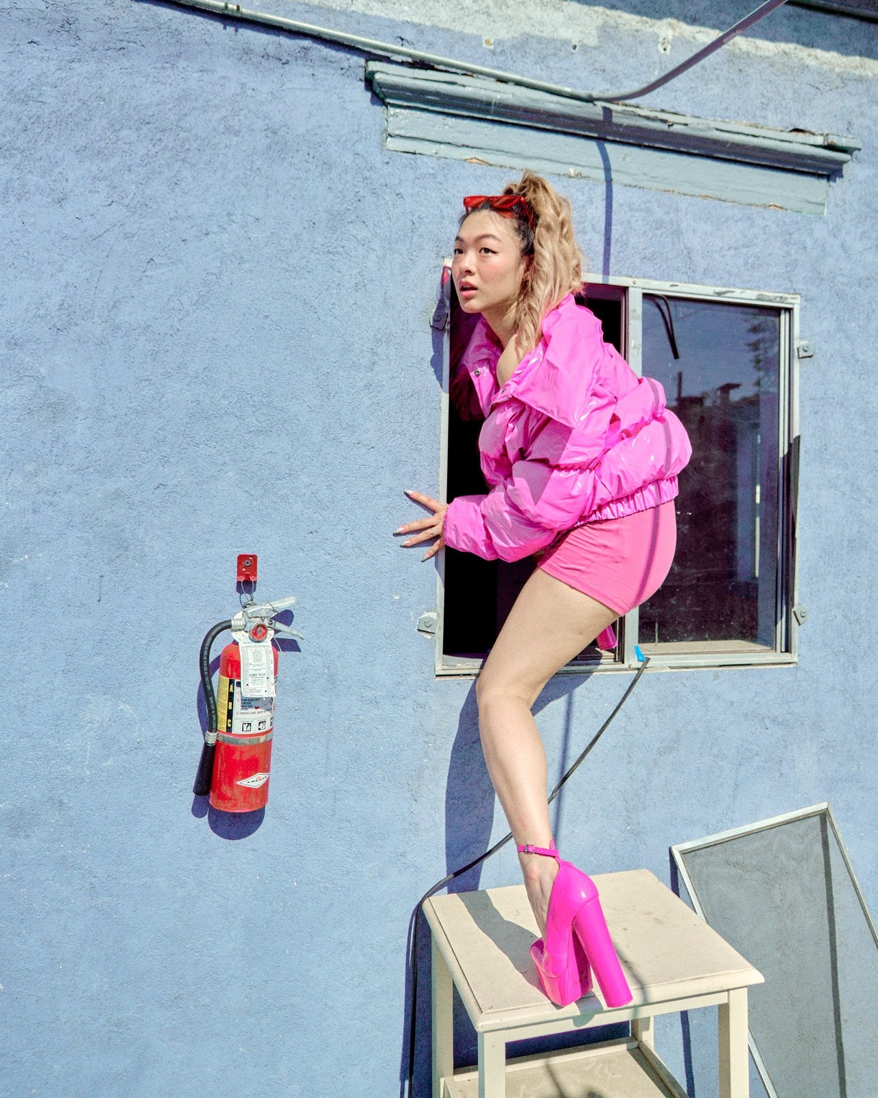 Pink jacket, climbing through a window