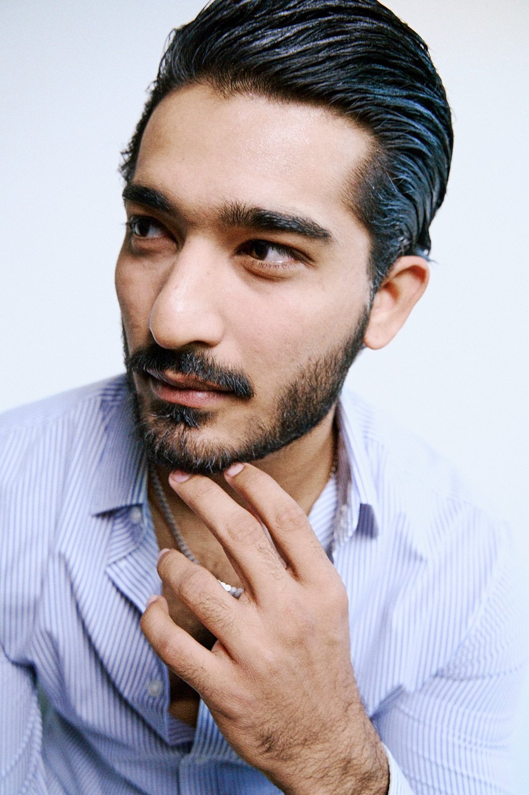Striped shirt, hand at the chin