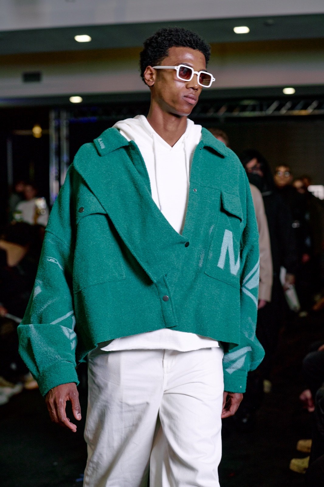 Green varsity jacket and white sunglasses